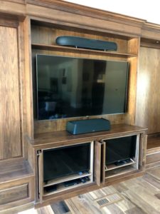 audio video installation with flat screen tvs and center channel speaker installed in custom cabinet