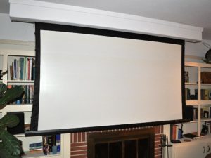motorized screen dropped down to show custom audio video installation in front of fireplace